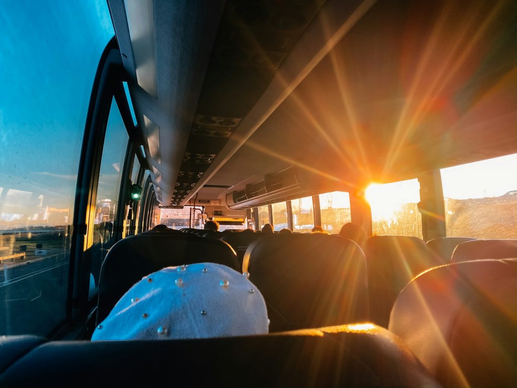 Bus trip, passengers on a bus with sun shining through window