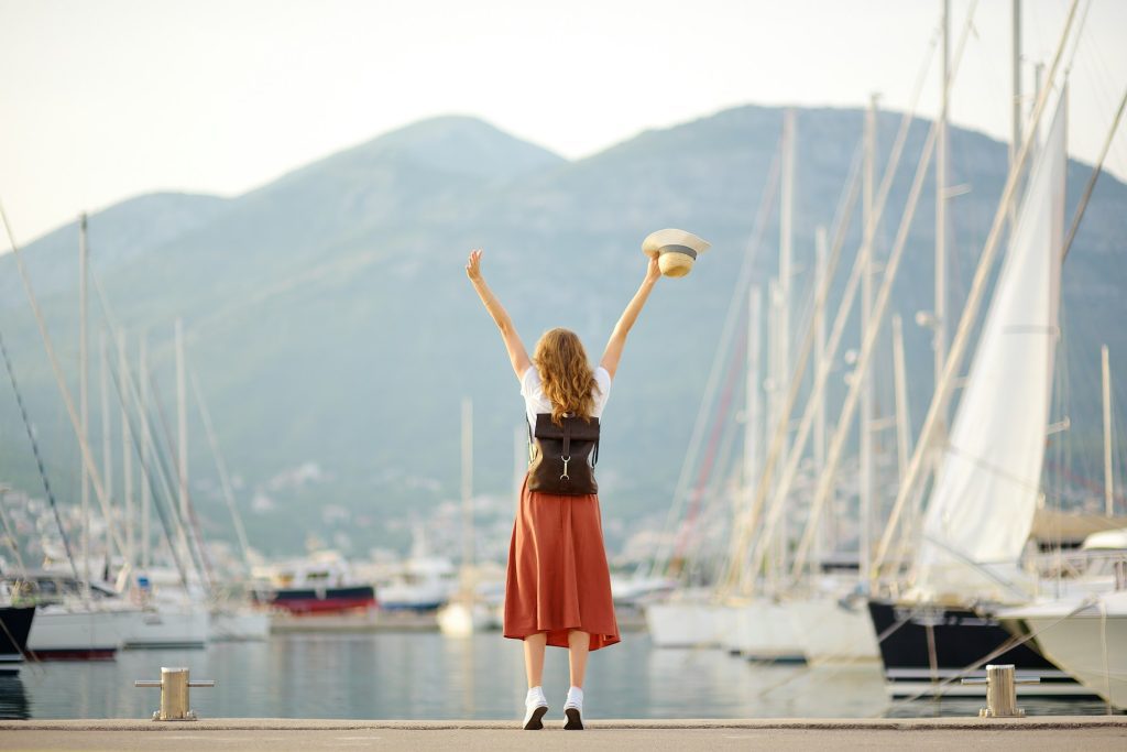 Charming young woman meets someone from a voyage on the Mediterranean sea.