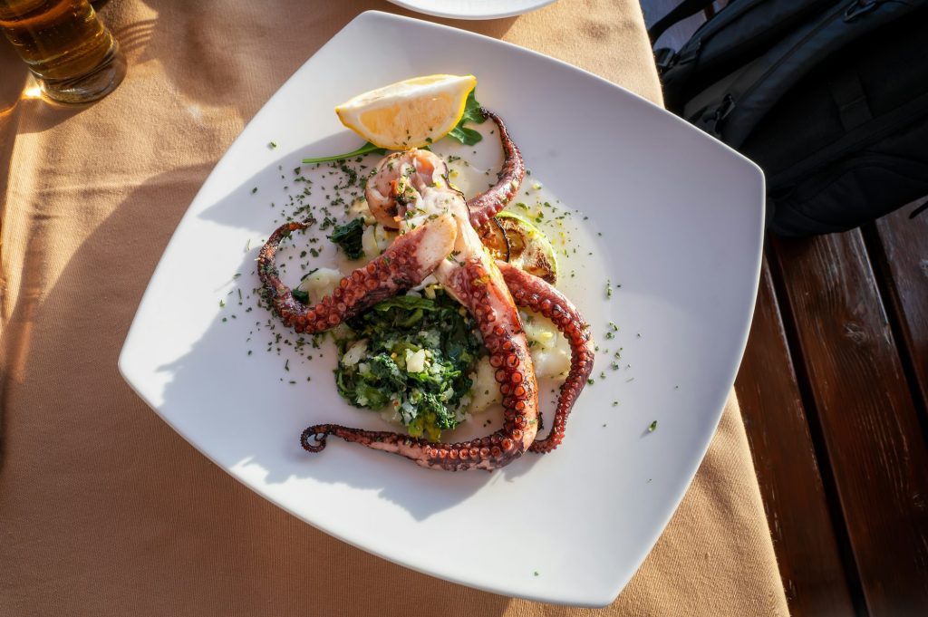 Grilled octopus on a plate with mashed potatoes and spinach
