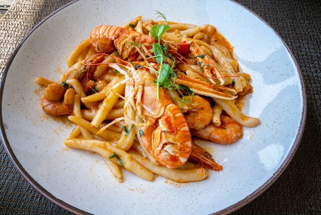 Top view of delicious dish of seafood with pasta and tomato sause